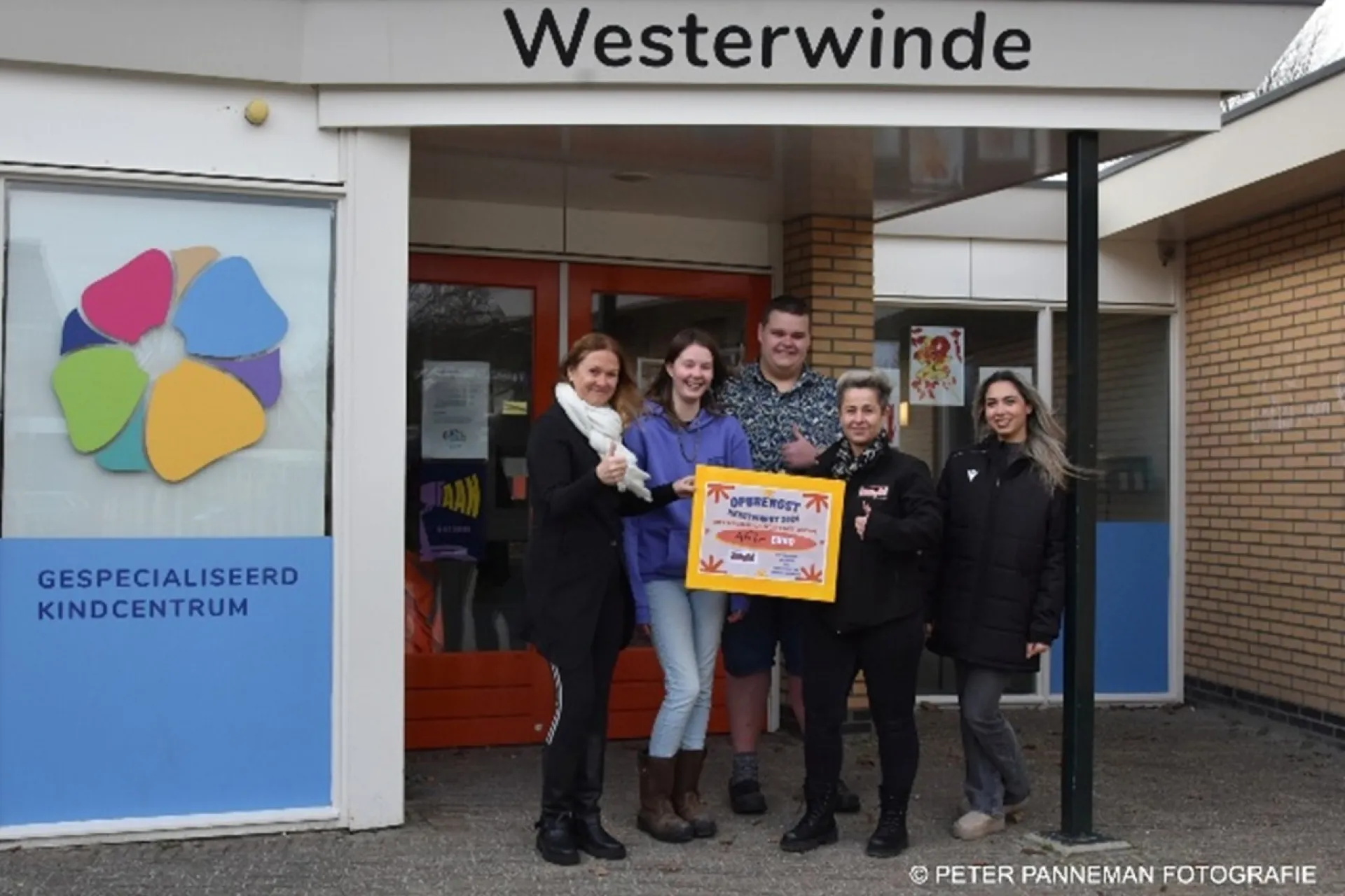 Een groep volwassenen en kinderen die binnen een spelletje spelen, ze gooien een nep sneeuwbal in een bak. Dit was onderdeel van de Elfstedenbijeenkomst van Summerfun.